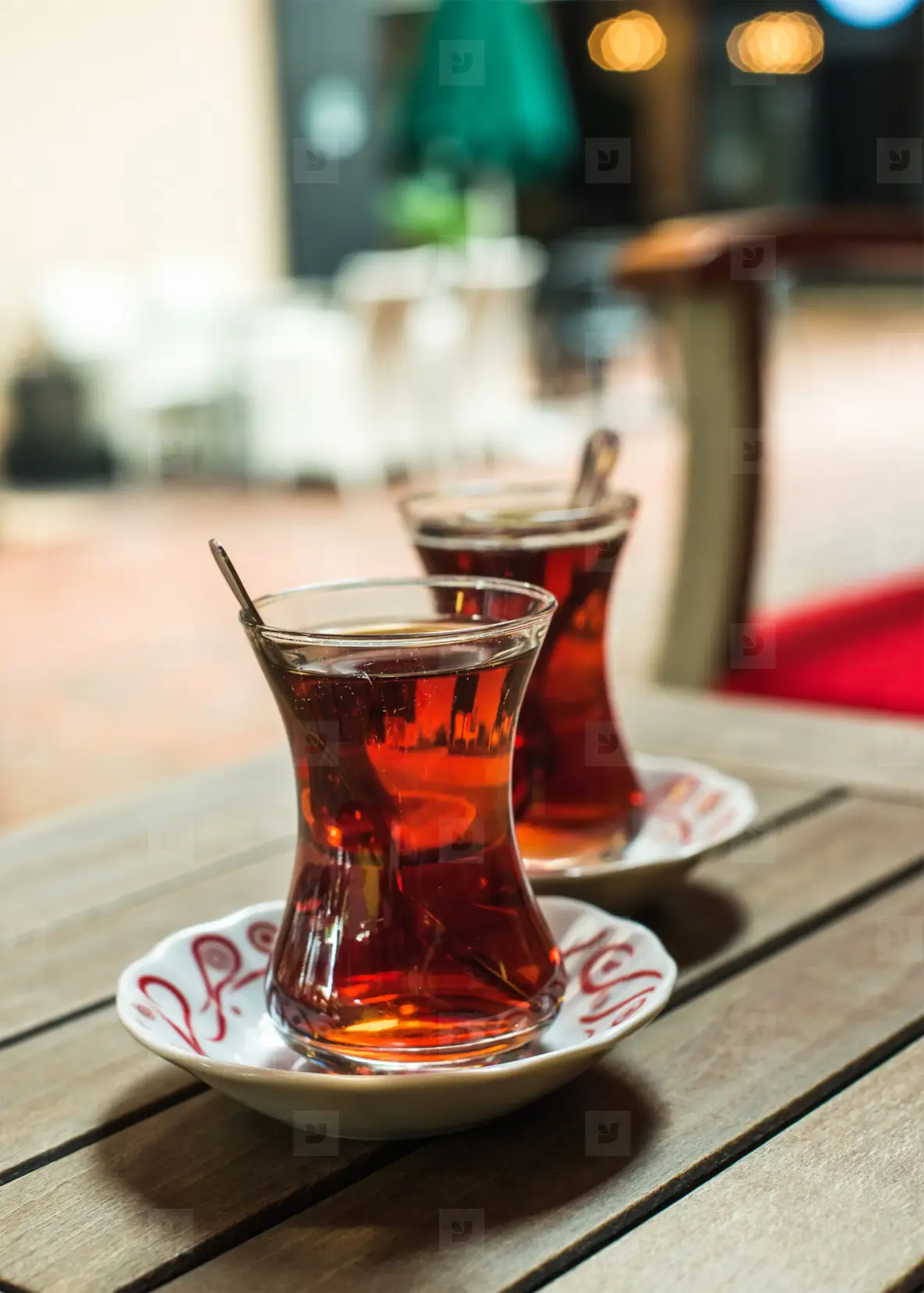A close-up of a traditional Turkish tea set with apple tea steaming in tulip glasses