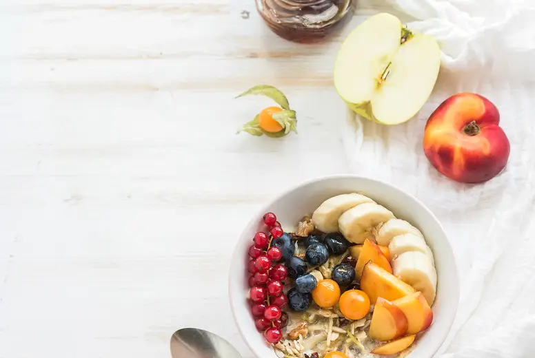 Healthy breakfast. Bowl of oat granola with yogurt, fresh berries, fruit and honey. Top view