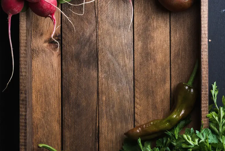 Fresh raw ingredients for healthy cooking or salad making  in rustic wooden tray over black background, top view, copy space. Diet, vegetarian food concept.