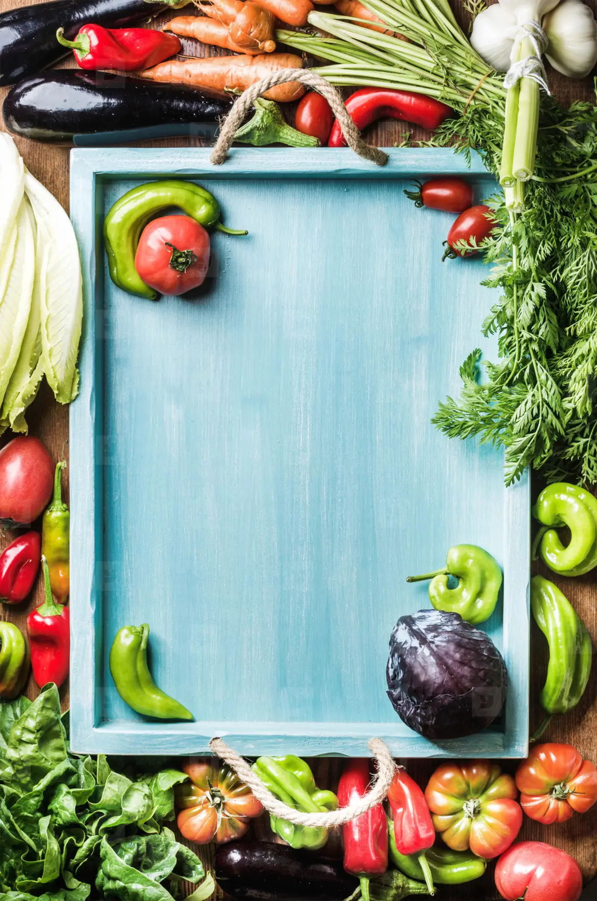 Fresh raw vegetable ingredients for healthy cooking or salad making on wooden background and blue  tray in center  top view  copy space