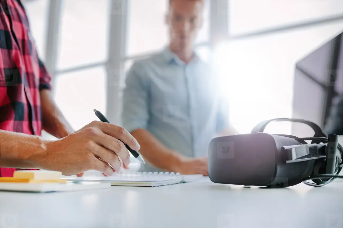 Virtual reality glasses on table with men working