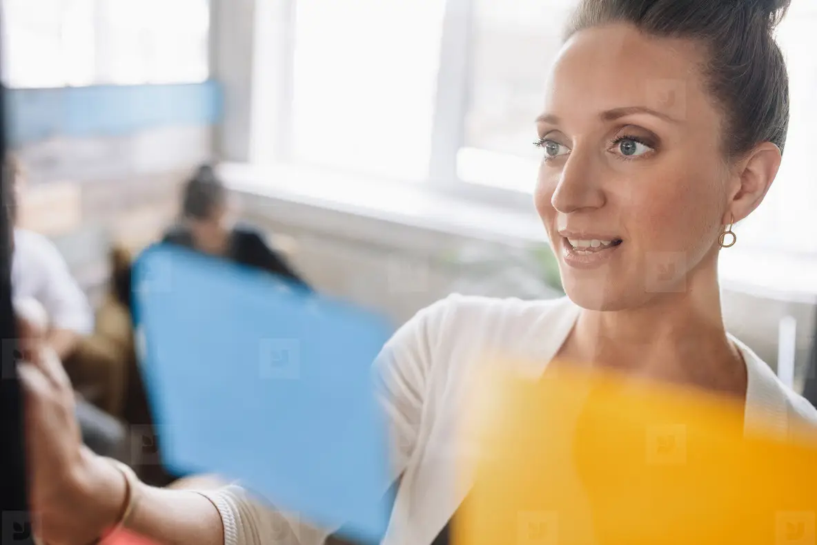 Young Woman Looking Over A Post It Note Photo (125429) - YouWorkForThem
