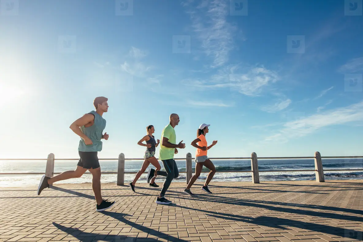 Group of athletes running on ocean front