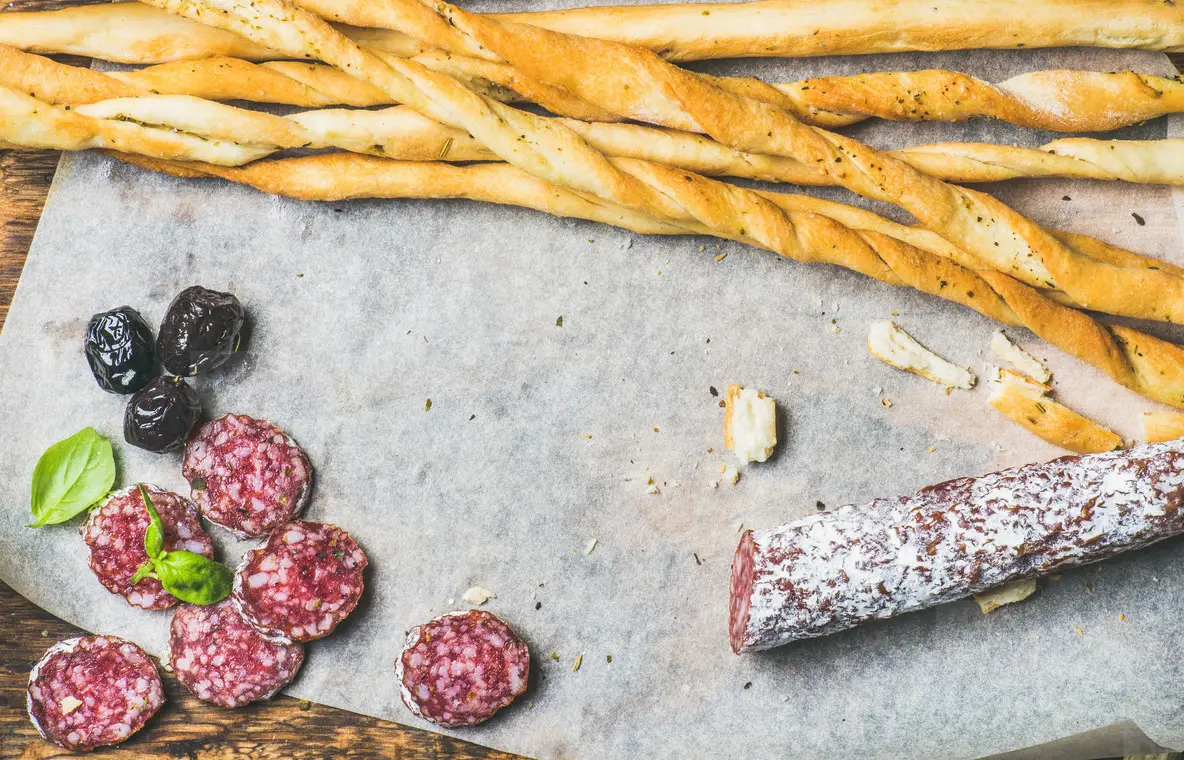 Grissini bread sticks  sausage  olives and red wine  copy space