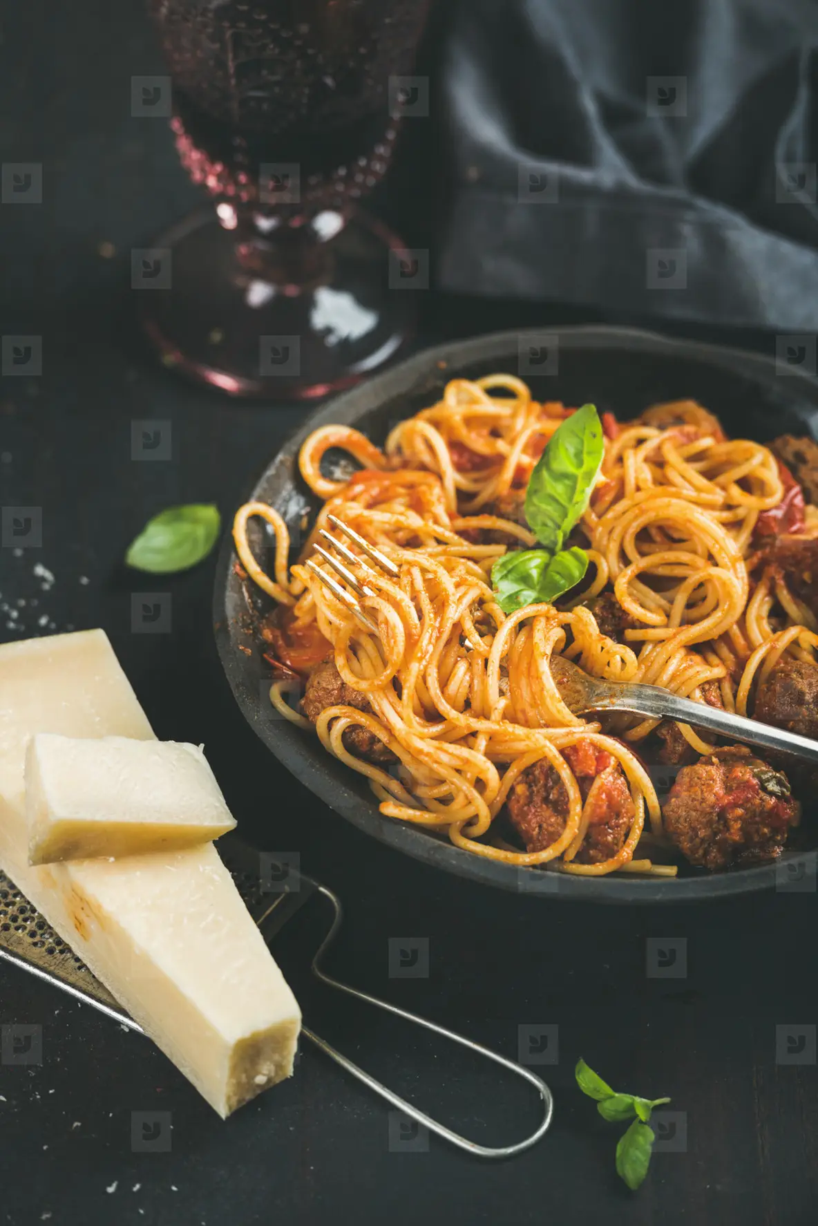Spaghetti with meatballas  basil  parmesan cheese in black plate