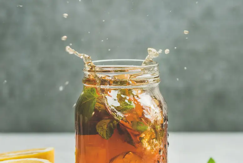 Summer Iced tea with lemon and herbs, copy space