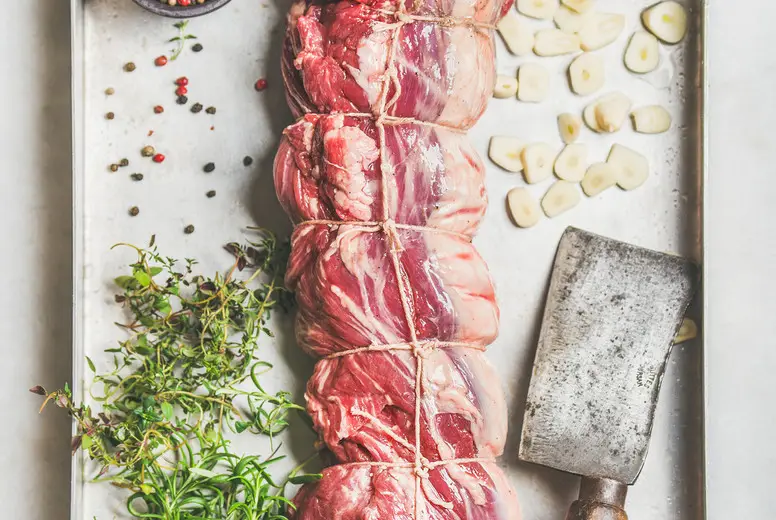 Raw uncooked roast beef meat with garlic and spices
