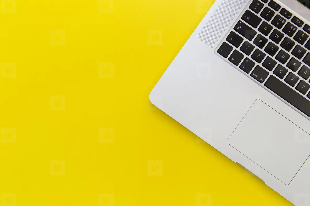 Laptop computer on bright yellow background