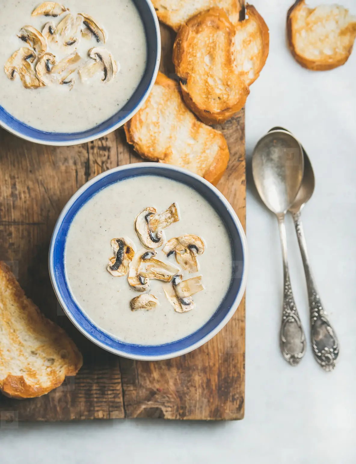 Close up of creamy mushroom soup in bowls with grilled bread