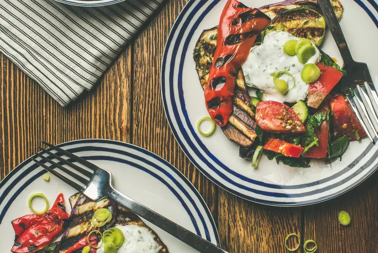 Flat-lay of healthy dinner table setting with vegetables