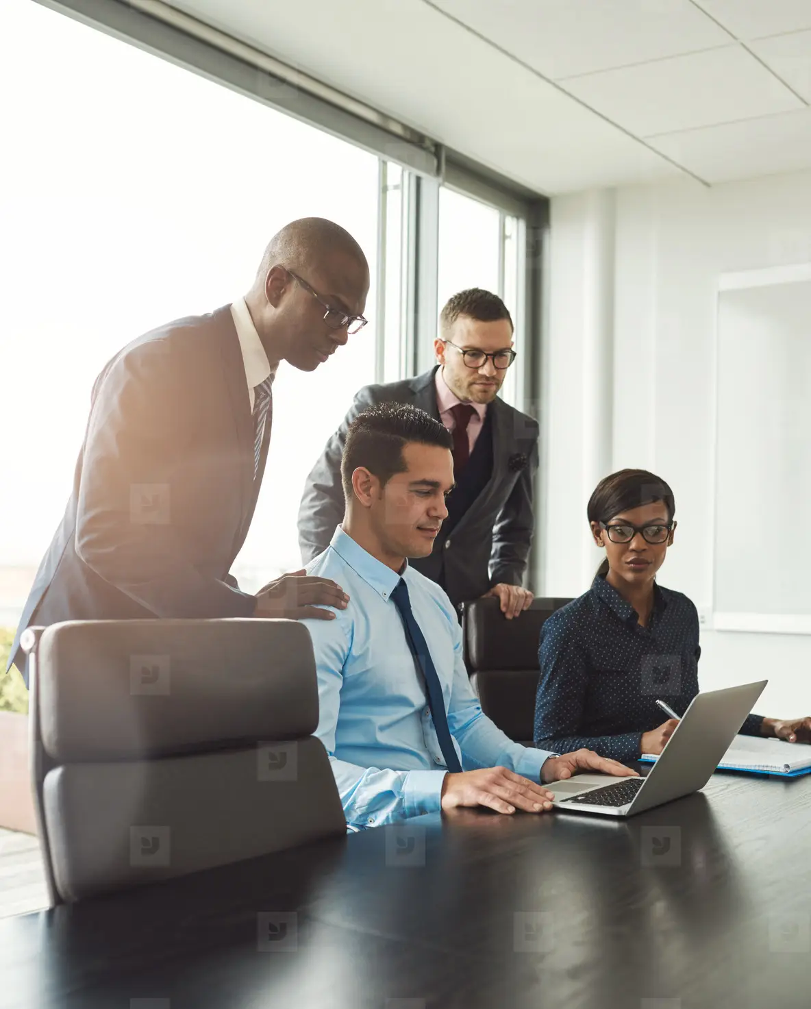 Group of co workers looking at laptop on table