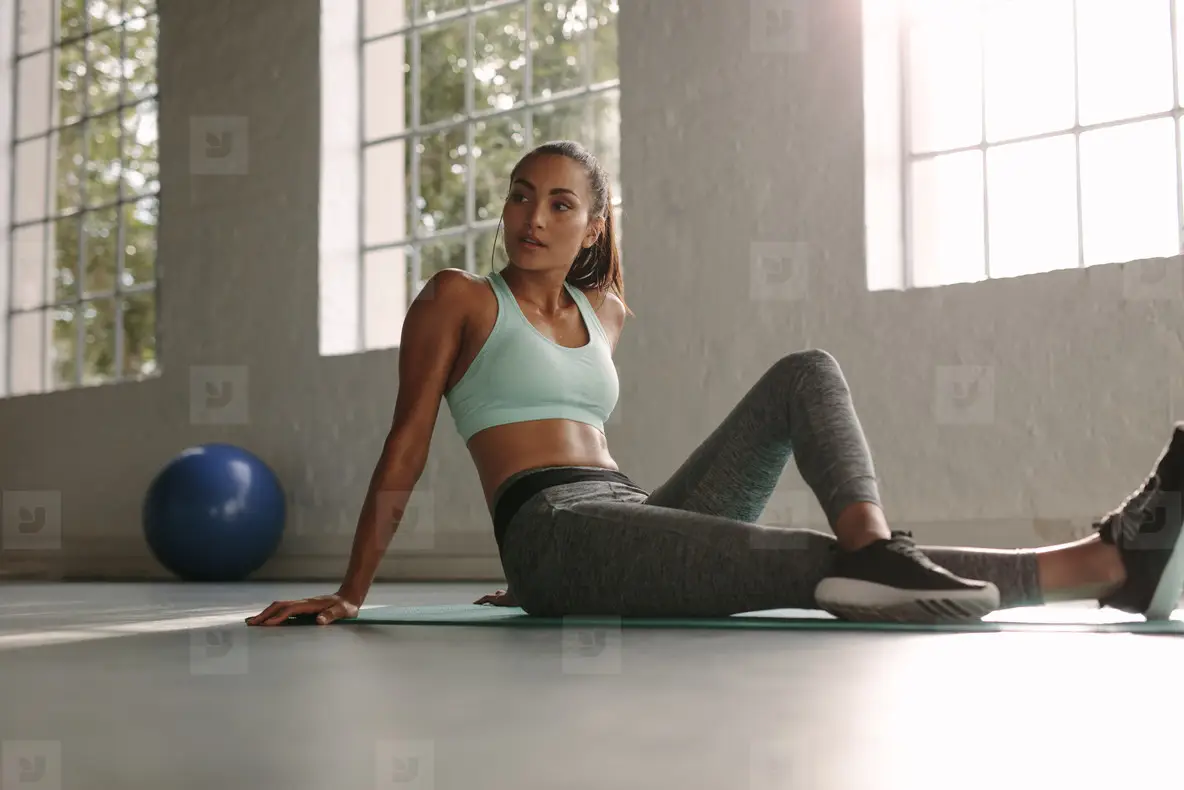 Female Athlete Sitting On Exercise Mat At Fitness Club Photo (138695 ...