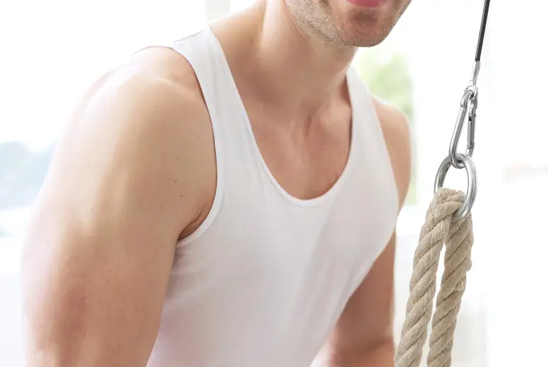 Smiling Muscular Young Guy Pulling Down Pulley