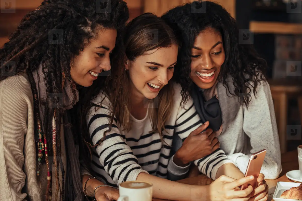 Friends at a cafe looking at mobile phone