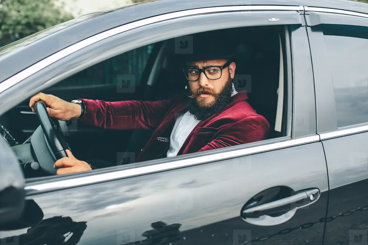 Man with beard driving a car
