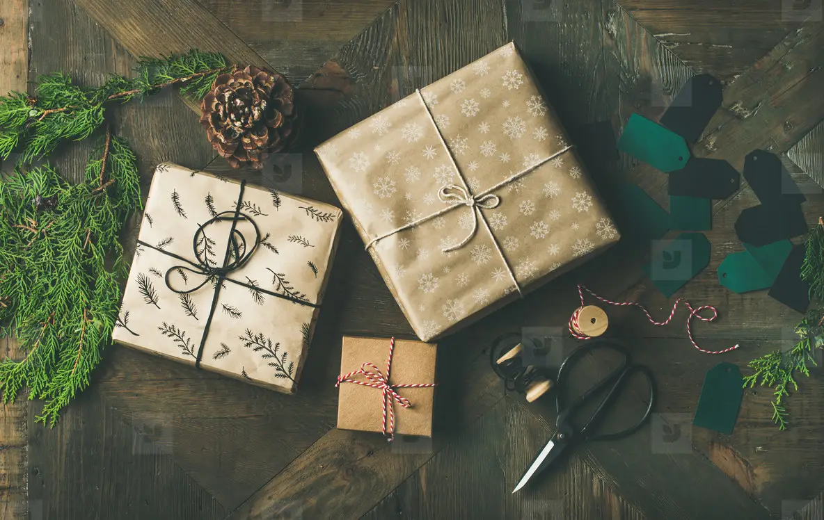 Flat lay of gift boxes  rope  fur branches  scissors  cones  stickers