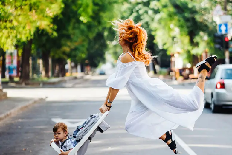 mom with a stroller crosses the road