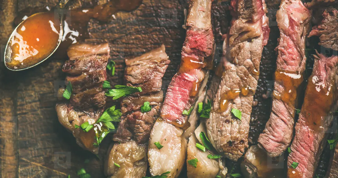 Flat lay of grilled ribeye beef steak cut into peices