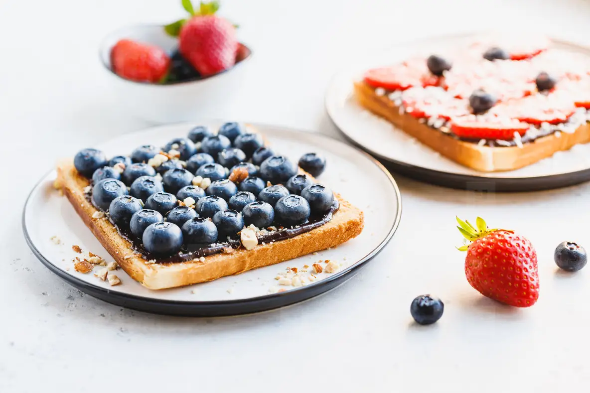 Close up of breakfast sweet toast with chocolate spread  hucklberry and crashed almond