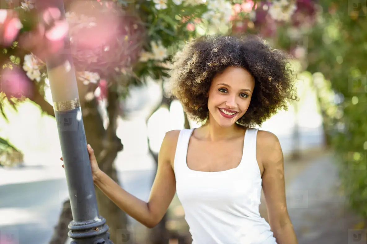 Young Black Woman With Afro Hairstyle Smiling In Urban Park Photo ...