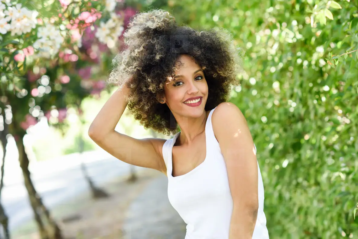 Young Black Woman With Afro Hairstyle Smiling In Urban Park Photo ...