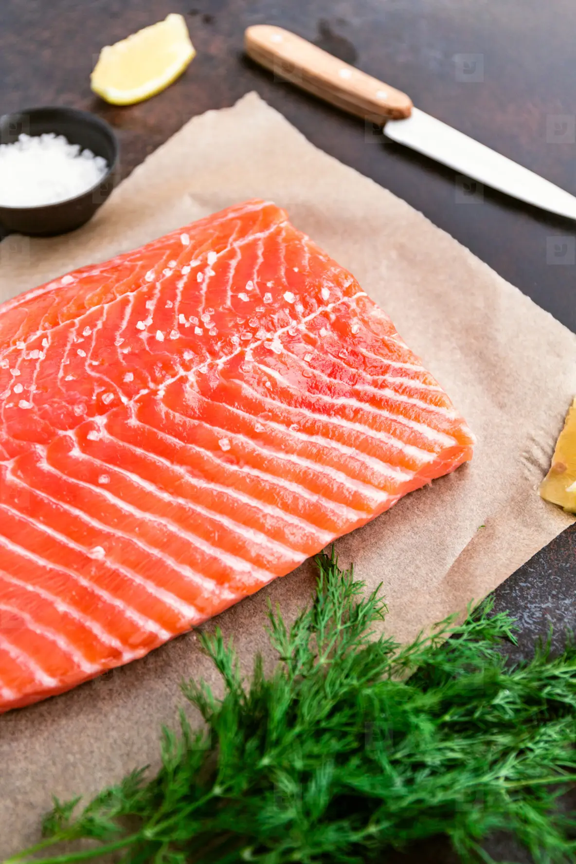 Fresh raw salmon fillet with dill  sea salt and lemon on a table for cooking  Recipe for ketogenic or paleo diet
