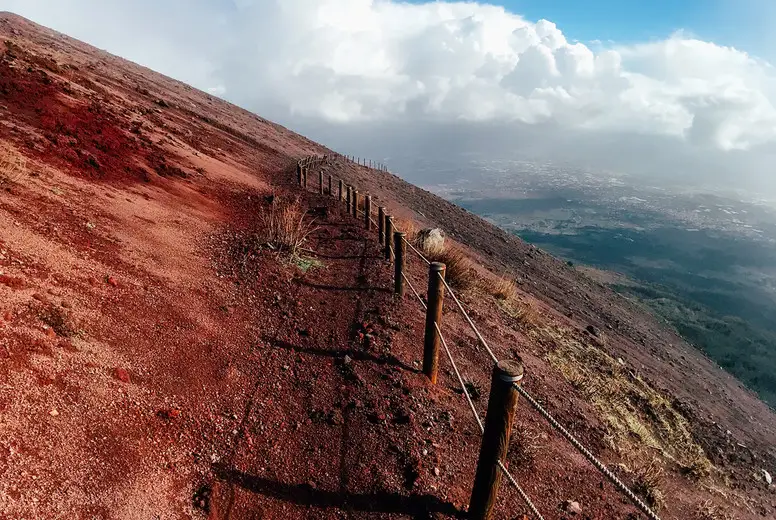 A mountain path bordered by red cliffs