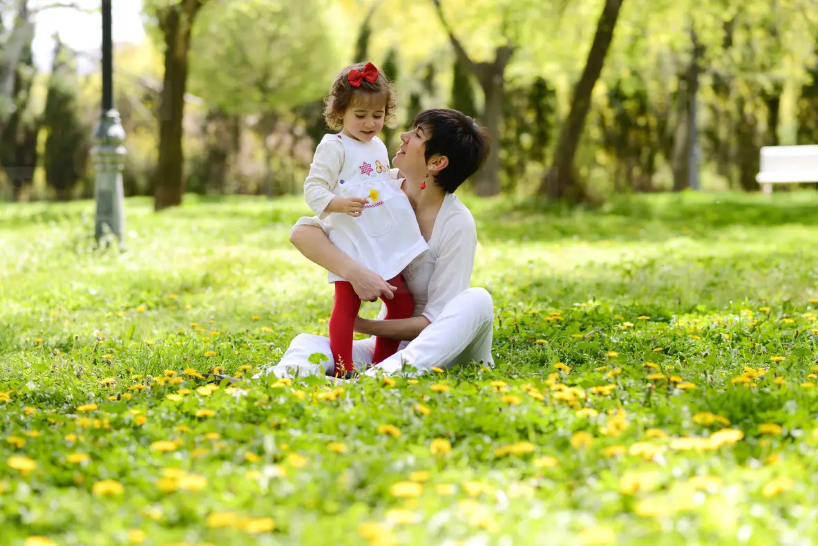 Mother and little girl playing in the park