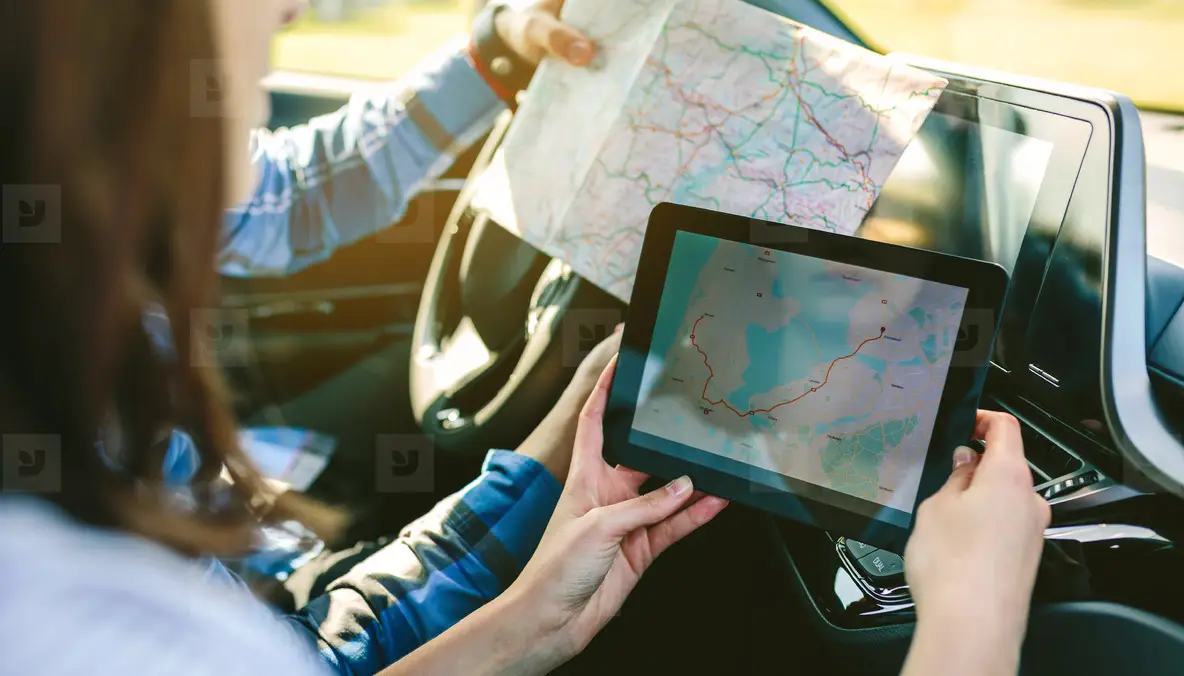 Couple comparing paper map and a gps navigator