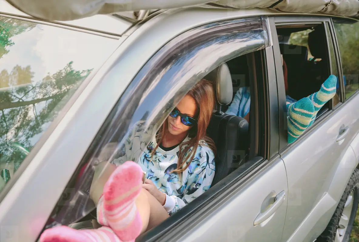 Women resting with her legs over open window car