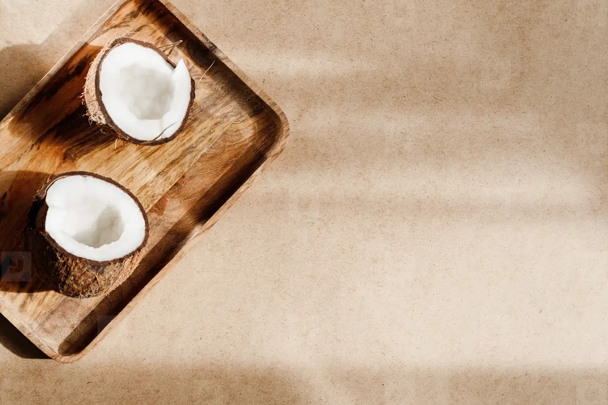 Summer abstract creative composition with coconut a on wooden tray over kraft paper