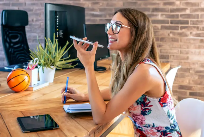 Office worker talking mobile phone with speaker