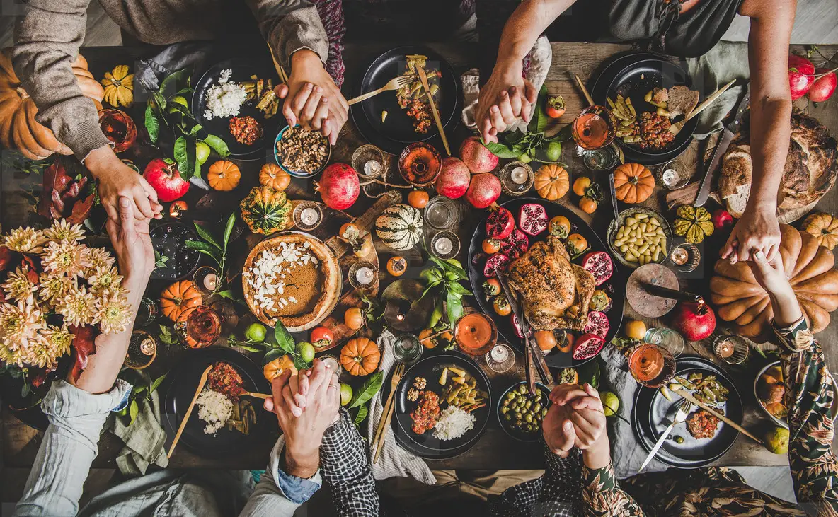 Family Or Friends Praying Holding Hands At Thanksgiving 
