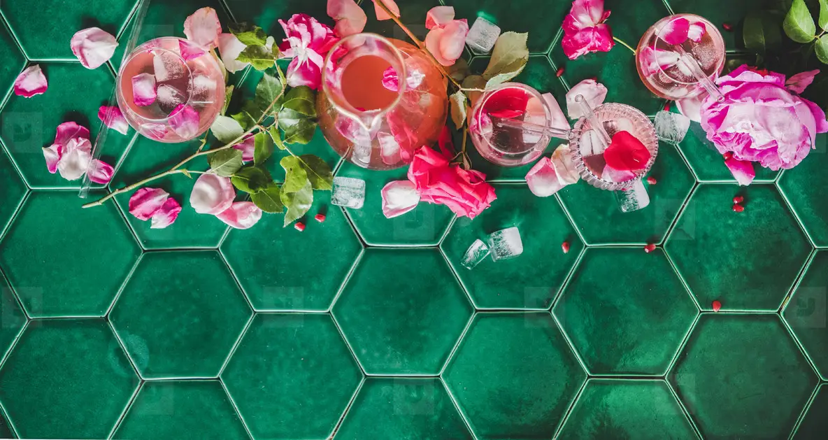 Flat lay of rose lemonade with ice and rose petals