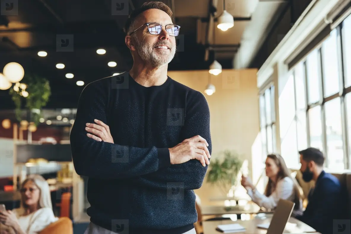 Contemplative businessman standing in a co working space