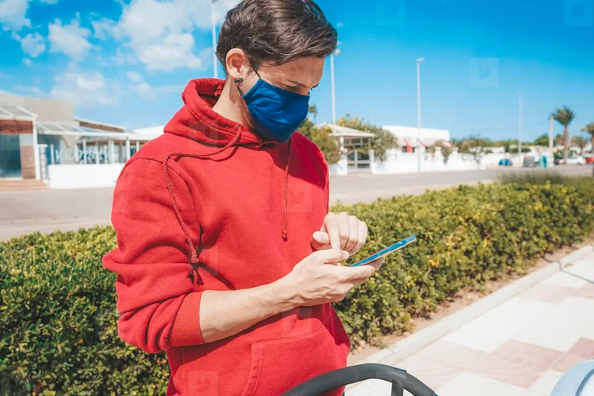 Men using his smartphone with a face mask in Spain