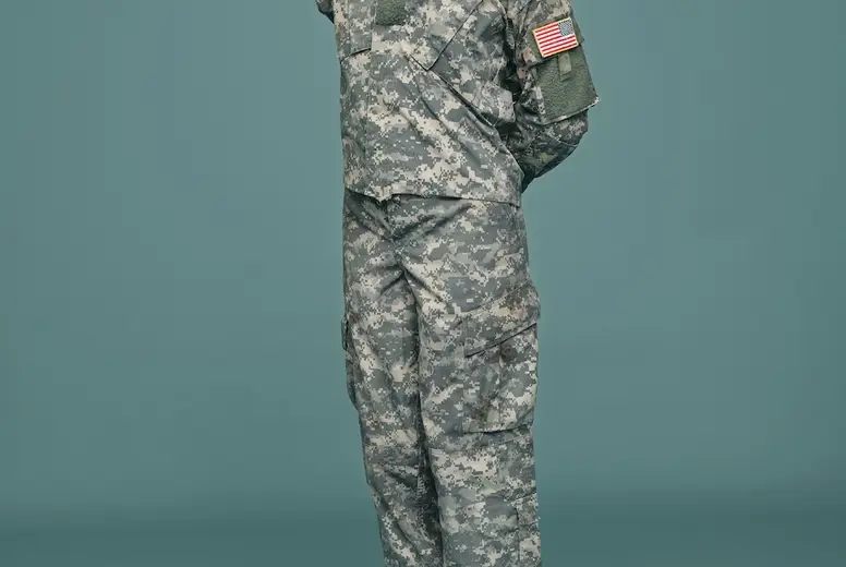 Courageous army soldier saluting in a studio