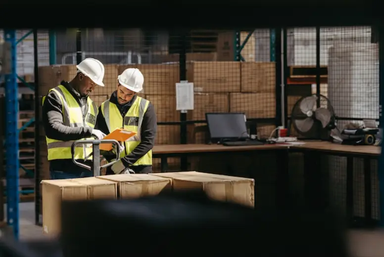 Warehouse employees reading a clipboard in a logistics centre