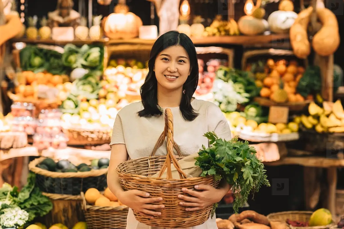 Smiling Asian Woman Holding A Wicker Basket With Vegetables. Young ...