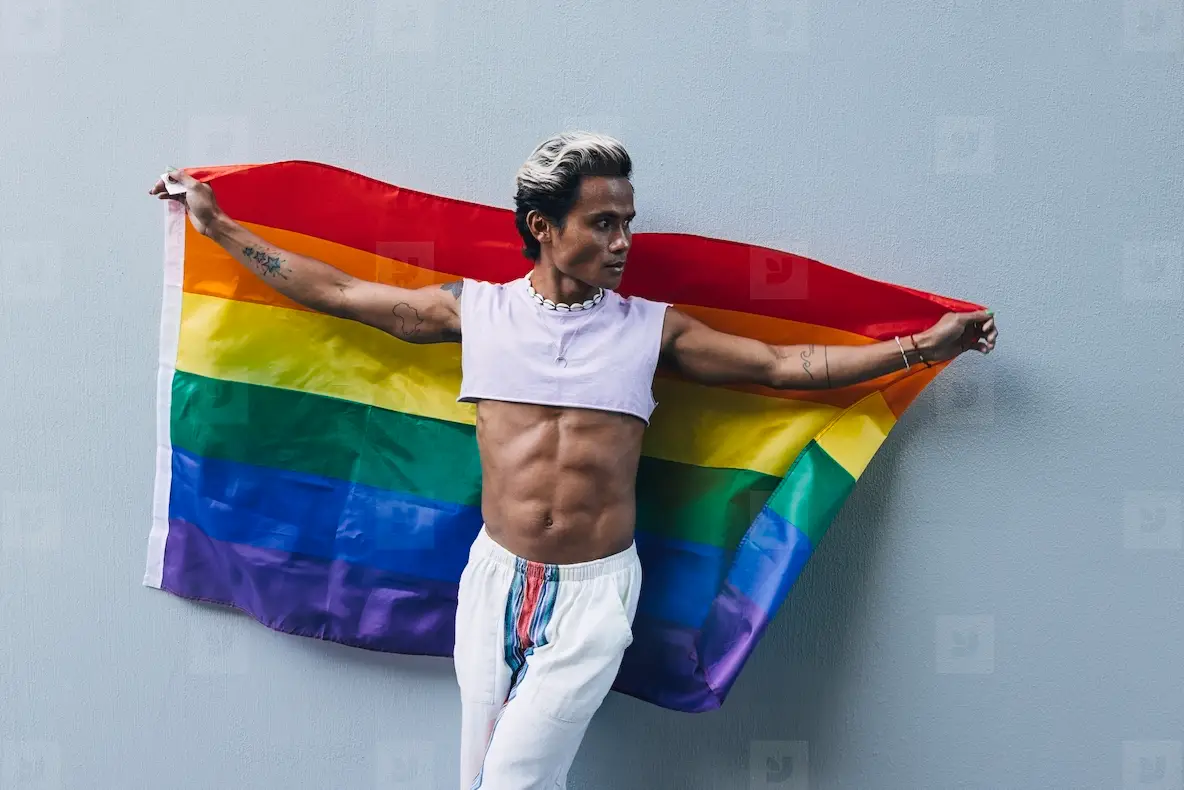 Muscular Stylish Guy Holding An LGBT Rainbow Flag At A Grey Wall Photo ...