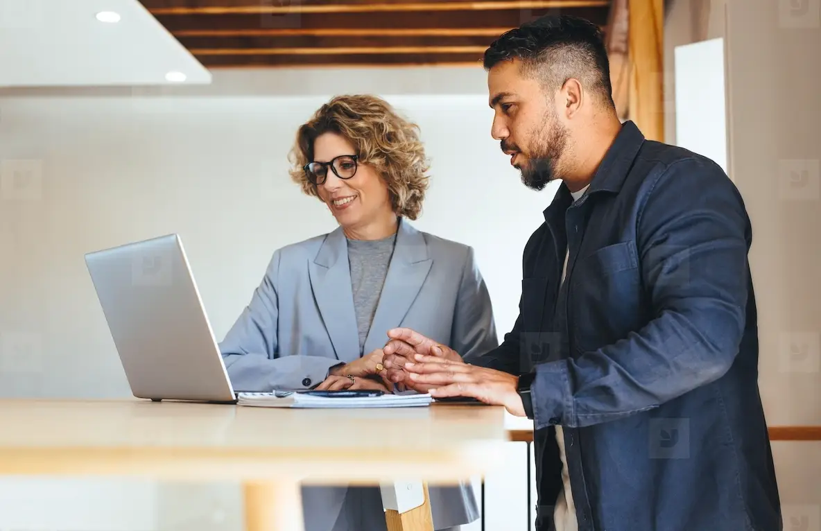 Business people discussing their work progress using a laptop