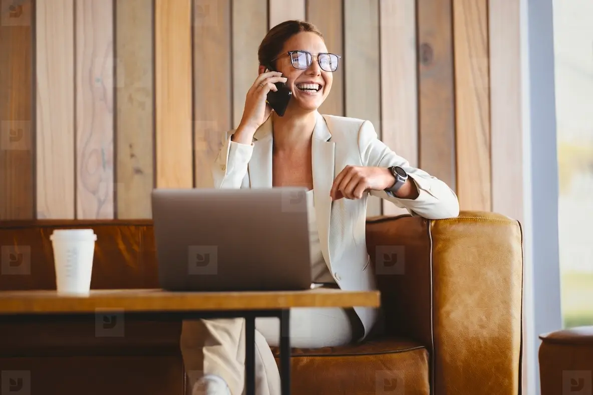 Successful female entrepreneur calling from her smartphone in a work setting