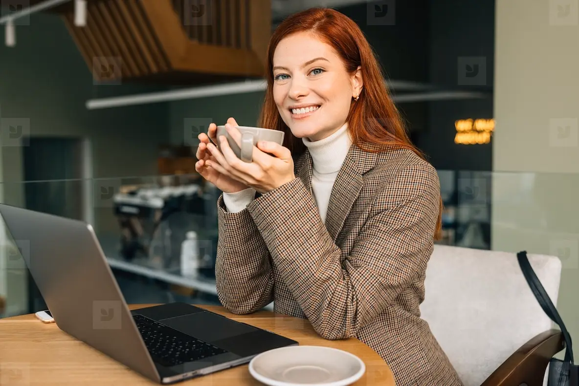 Smiling Businesswoman Holding A Cup Of Coffee And Looking At The Camera ...