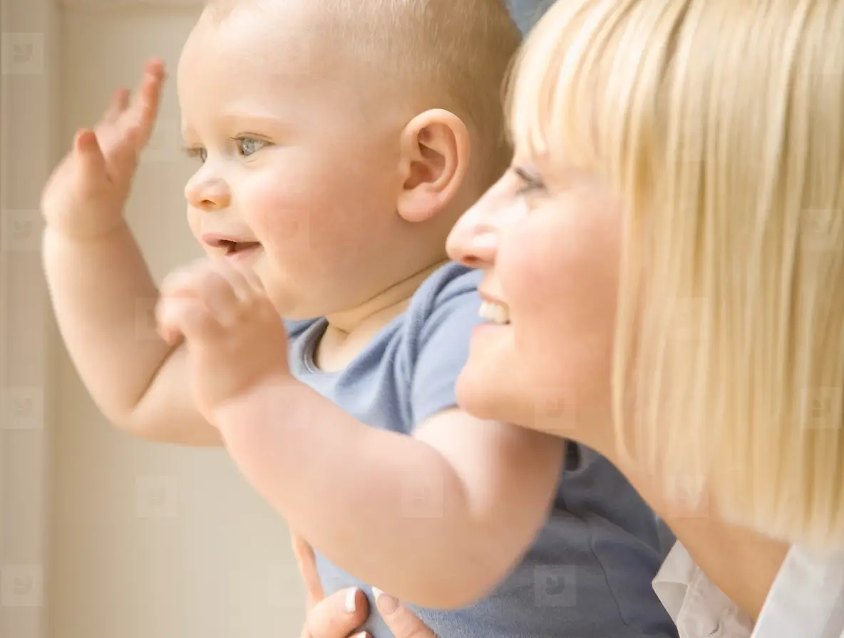 Close Up Of A Baby Waving His Arms With His Mother Holding Him Photo ...