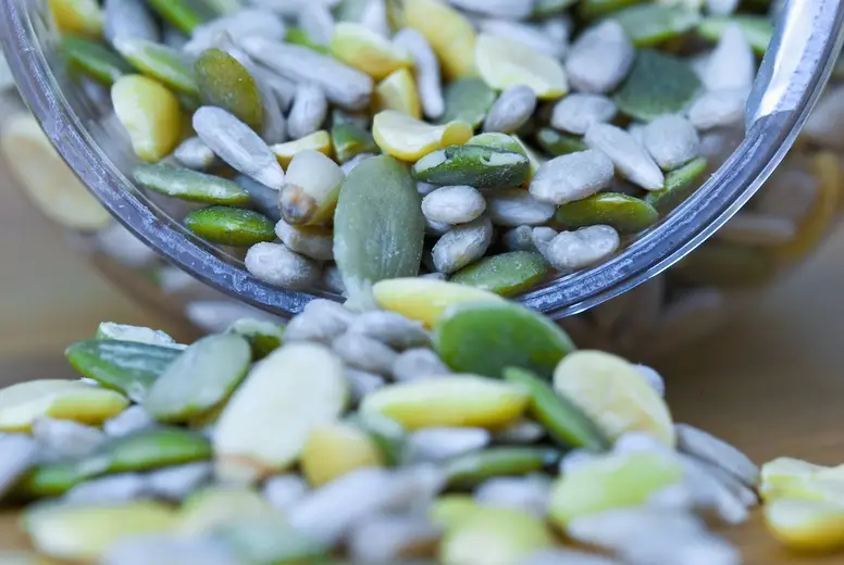 Close up of mixed seeds spilling out of a container