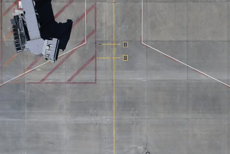 View from above passenger boarding bridge and road markings on airport tarmac