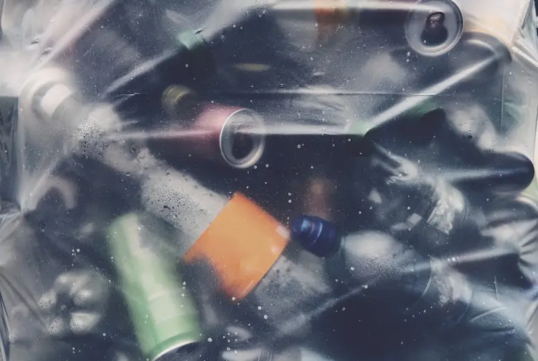 Full frame close up plastic bottles and aluminum cans in recycling bag