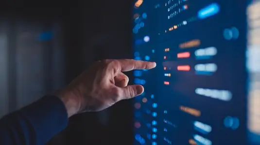 hand interacts with digital interface displaying data and algorithms