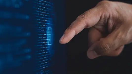 hand interacts with digital interface displaying glowing data