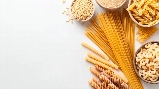 variety of dried pasta neatly arranged on white background